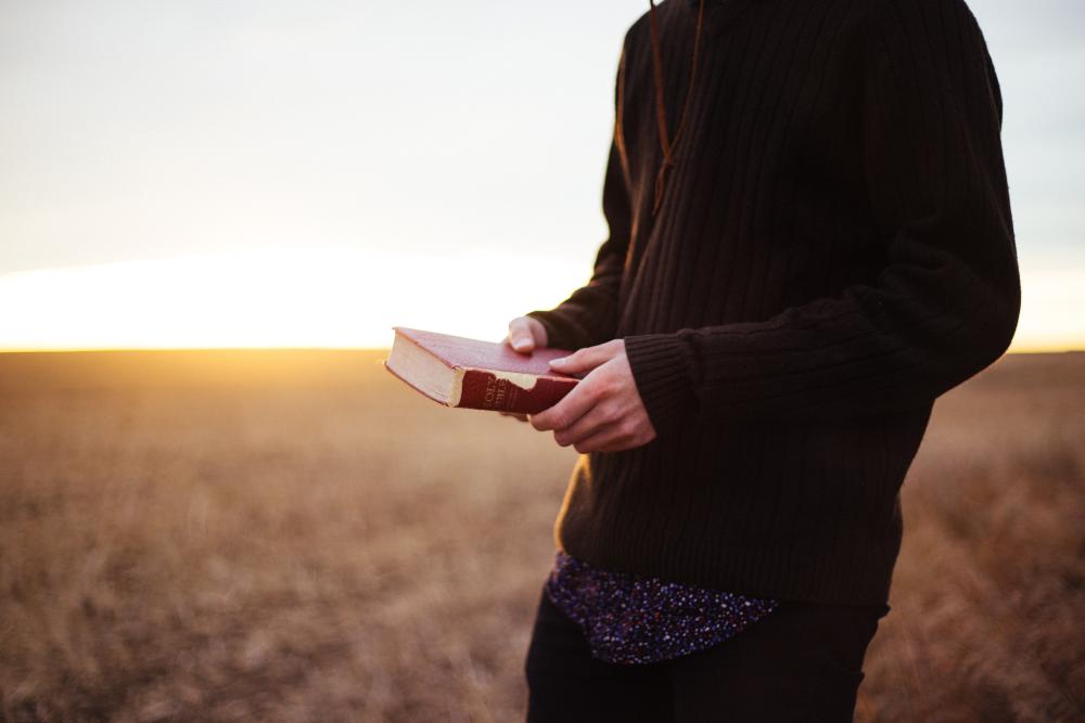 Mies, jolla on Raamattu kädessä. Kuva Priscilla Du Preez / Unsplash 
